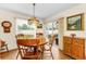 Dining area featuring a wooden table, chairs, and backyard views from windows at 8060 Timberlake Ave, Spring Hill, FL 34606