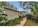 Side view of the home featuring lush landscaping and walkway at 8060 Timberlake Ave, Spring Hill, FL 34606