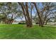 Well-manicured front lawn, mature trees, and inviting driveway enhance the home's curb appeal at 8060 Timberlake Ave, Spring Hill, FL 34606