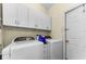 Convenient laundry room with a washer, a dryer, and white cabinets for storage at 8060 Timberlake Ave, Spring Hill, FL 34606