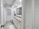 Bright bathroom with shuttered window, and white cabinets at 8127 Siquita Ne Dr, St Petersburg, FL 33702
