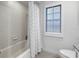 Bright bathroom with shower-tub combo with shuttered window at 8127 Siquita Ne Dr, St Petersburg, FL 33702