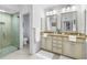 Bright bathroom featuring dual sinks, granite countertop, and glass enclosed shower at 8127 Siquita Ne Dr, St Petersburg, FL 33702