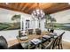 Dining room features a unique mural, wood plank ceiling, chandelier and glass table set for a dinner party at 8127 Siquita Ne Dr, St Petersburg, FL 33702