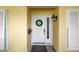 Close-up of the front door featuring a festive wreath, stylish lighting, and a welcoming entrance with neutral siding at 8127 Siquita Ne Dr, St Petersburg, FL 33702