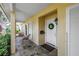 Cozy front porch featuring a tiled floor, comfortable seating, and a welcoming entrance with a decorated front door at 8127 Siquita Ne Dr, St Petersburg, FL 33702
