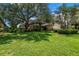 Well-manicured front yard showcasing a lush lawn, mature trees, and a charming home exterior with great curb appeal at 8127 Siquita Ne Dr, St Petersburg, FL 33702