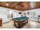 Elegant game room featuring a wood plank ceiling, a pool table, windows with shutters, and access to other areas at 8127 Siquita Ne Dr, St Petersburg, FL 33702