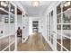 Bright hallway with beautiful tile floors, decorative art, and glass paneled doors leading to multiple rooms of the house at 8127 Siquita Ne Dr, St Petersburg, FL 33702