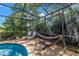 Relaxing screened-in pool area with sun loungers and hammock surrounded by lush tropical greenery at 8127 Siquita Ne Dr, St Petersburg, FL 33702
