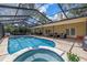 Inviting backyard with pool and jacuzzi, offers a comfortable lounge area and outdoor dining, perfect for entertaining at 8127 Siquita Ne Dr, St Petersburg, FL 33702