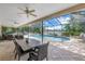 Screened in patio and pool with lounge chairs and dining area overlooking the lake at 8127 Siquita Ne Dr, St Petersburg, FL 33702