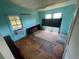 Bedroom with two windows, wood floors, blue walls and headboards leaning against the wall at 834 Grand Central St, Clearwater, FL 33756