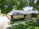 Exterior elevation of villa showcasing well-manicured lawn and mature landscaping at 860 Maclaren N Dr # A, Palm Harbor, FL 34684