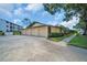 Low angle, exterior elevation of villa displaying the complex's curb appeal, landscaping, and parking at 860 Maclaren N Dr # A, Palm Harbor, FL 34684