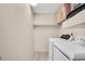 Functional laundry room featuring a washer, dryer, storage shelves, and tiled floors at 860 Maclaren N Dr # A, Palm Harbor, FL 34684