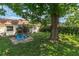 Landscaped backyard with mature tree, playhouse, screened patio and lush green lawn at 9831 83Rd Way, Seminole, FL 33777