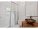 Modern bathroom with a unique sink, vanity, and a stylish shower curtain, creating a functional space at 9831 83Rd Way, Seminole, FL 33777