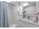 Clean bathroom featuring a shower with a blue curtain, white tile, and fresh decor at 9831 83Rd Way, Seminole, FL 33777