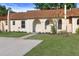 Charming townhouse featuring an arched entryway, fresh landscaping, and a spacious driveway at 9831 83Rd Way, Seminole, FL 33777