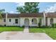 Charming single-story home with a well-maintained lawn, arched entryway, and light yellow exterior at 9831 83Rd Way, Seminole, FL 33777