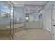Bright bathroom featuring a glass-enclosed shower, soaking tub, double vanity, and neutral tile flooring at 10646 Cory Lake Dr, Tampa, FL 33647