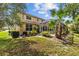 Beautiful home exterior showcasing lush landscaping, mature trees, and a screened-in pool area at 10646 Cory Lake Dr, Tampa, FL 33647