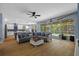 Open living room showcasing a comfortable gray sofa, wood floors, and sliding glass doors to the patio at 10646 Cory Lake Dr, Tampa, FL 33647