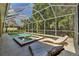 Inviting screened-in pool area with spa and lounge chairs for relaxing and enjoying the serene backyard view at 10646 Cory Lake Dr, Tampa, FL 33647