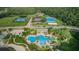 An aerial view of the community pool, various tennis courts, and lush green trees at 10724 Cory Lake Dr, Tampa, FL 33647
