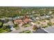 Aerial view of a neighborhood showcasing the property with a red tile roof, nearby homes, and a well-maintained street at 10724 Cory Lake Dr, Tampa, FL 33647