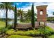 Welcoming entrance to Cory Lake Isles with lush landscaping and mature palm trees on a sunny day at 10724 Cory Lake Dr, Tampa, FL 33647