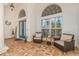 Cozy front porch with seating area, brick-paved floor, and decorative arched windows at 10724 Cory Lake Dr, Tampa, FL 33647