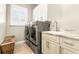Efficient laundry room with modern washer and dryer, storage cabinets, and tiled floor at 10724 Cory Lake Dr, Tampa, FL 33647