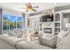 Bright living room with stone fireplace, ceiling fan, large windows, and view of the pool at 10724 Cory Lake Dr, Tampa, FL 33647