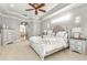 Comfortable main bedroom features a tray ceiling, ceiling fan, and ensuite bathroom at 10724 Cory Lake Dr, Tampa, FL 33647