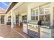 Outdoor kitchen featuring a built-in stainless steel grill with stone accents on a brick-paved patio at 10724 Cory Lake Dr, Tampa, FL 33647