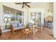 Outdoor seating area with comfortable gray cushions, ceiling fan, and sliding glass doors to the interior at 10724 Cory Lake Dr, Tampa, FL 33647