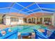 Inviting screened pool with blue sunshade, chairs, and brick patio, perfect for outdoor relaxation and entertaining at 10724 Cory Lake Dr, Tampa, FL 33647