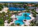 Aerial view of a community pool with water features, palm trees, lounge chairs, and well-maintained landscaping at 10724 Cory Lake Dr, Tampa, FL 33647