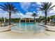Community pool with zero entry and water features, surrounded by lounge chairs and lush greenery at 10724 Cory Lake Dr, Tampa, FL 33647
