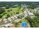 Aerial shot captures a golf course community featuring lush landscaping, serene ponds, and two pristine tennis courts at 11016 Kiskadee Cir, New Port Richey, FL 34654