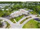 An aerial view of a community building with a pool, parking, and landscaped grounds surrounded by trees at 11016 Kiskadee Cir, New Port Richey, FL 34654