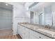 Bright bathroom features a granite countertop, dual sinks, and walk in closet, creating a luxurious and functional space at 11016 Kiskadee Cir, New Port Richey, FL 34654