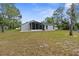 The backyard boasts a screened lanai, home exterior and mature trees at 11225 Flower Ave, Weeki Wachee, FL 34613
