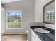 Bathroom featuring a granite countertop, modern fixtures, and a large window with a verdant view at 11225 Flower Ave, Weeki Wachee, FL 34613