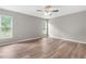 Light-filled bedroom featuring neutral walls, hardwood floors, and two windows at 11225 Flower Ave, Weeki Wachee, FL 34613