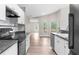 Bright kitchen featuring white cabinets, dark countertops, and wood-look floors connects seamlessly to the rest of the home at 11225 Flower Ave, Weeki Wachee, FL 34613