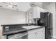 Functional kitchen with granite countertops, stainless steel appliances, and white cabinetry under a vaulted ceiling at 11225 Flower Ave, Weeki Wachee, FL 34613