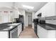 Functional kitchen with white cabinets, dark granite countertops, and stainless steel appliances under natural lighting at 11225 Flower Ave, Weeki Wachee, FL 34613